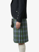 Person wearing a black jacket and green plaid kilt on a white background