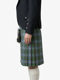 Person wearing a black jacket and green plaid kilt on a white background