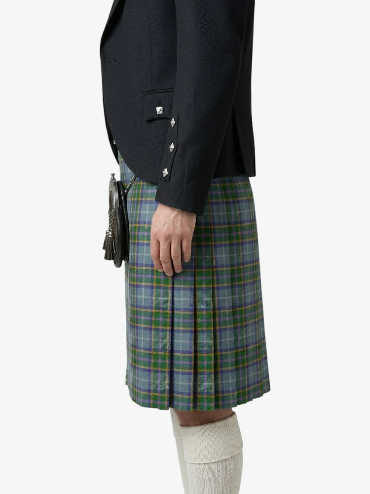 Person wearing a black jacket and green plaid kilt on a white background