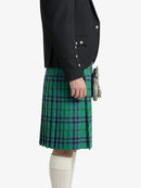 Person wearing a black jacket and green plaid kilt on a white background