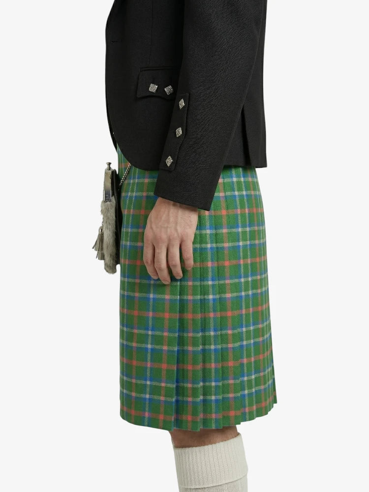 Person wearing a black jacket and green plaid kilt on a white background