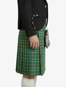 Person wearing a green plaid kilt with a black jacket on a white background