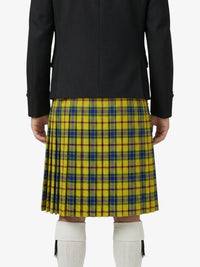 Person wearing a yellow plaid kilt with a black jacket on a white background