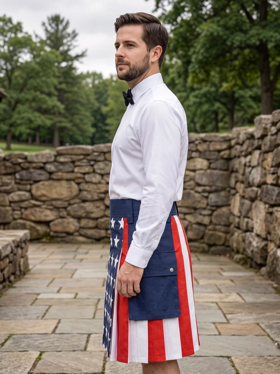 A man wearing a white dress shirt and black bow tie stands outdoors in profile, wearing a kilt with an American flag pattern featuring red and white stripes and a blue panel with white stars.