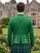 A man viewed from behind wearing a bright green Scottish kilt jacket with silver buttons and a green and blue tartan kilt, standing in a garden with a large stone mansion in the background.