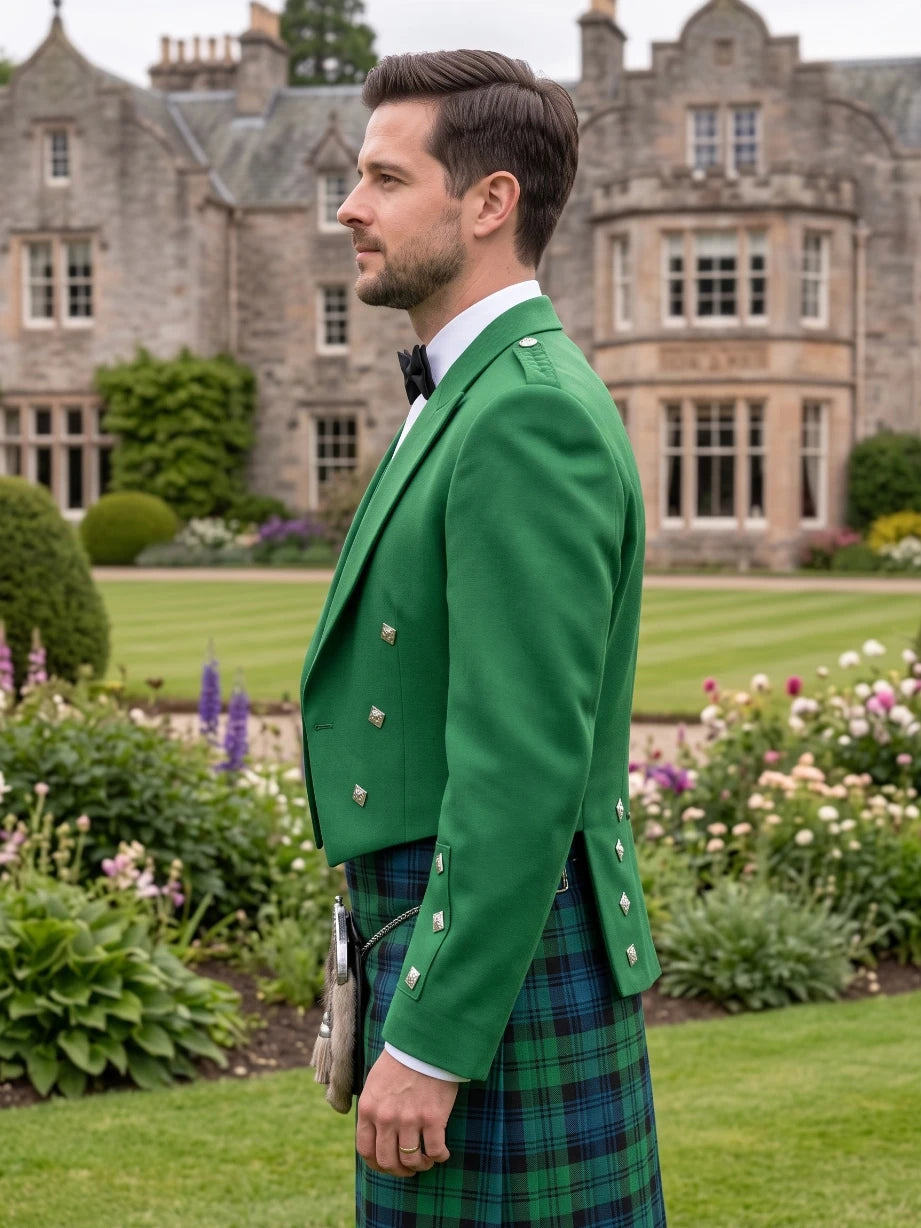 A man in profile wearing a bright green Scottish blazer and a green tartan kilt, standing in a lush garden with a large stone mansion in the background.