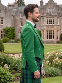 A man in profile wearing a bright green formal jacket, a green and black tartan kilt, and a black bow tie, standing in a garden with a large stone mansion in the background.