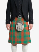 Person wearing a traditional Scottish kilt with a tartan pattern on a white background