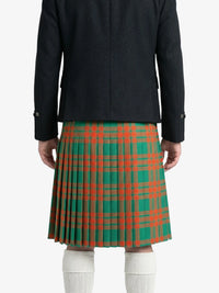 Person wearing a green and red plaid kilt with a black jacket on a white background