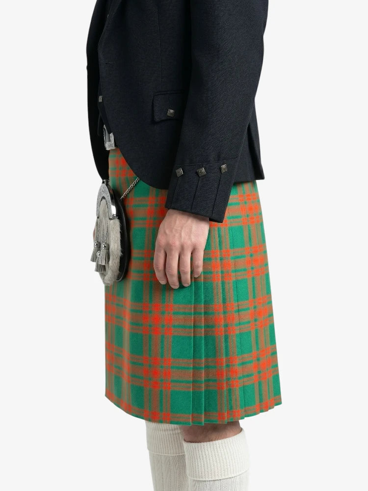 Person wearing a green and red plaid kilt with a black jacket on a white background