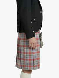 Person wearing a black jacket and plaid kilt on a white background