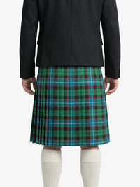 Person wearing a black jacket and green plaid kilt on a white background