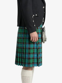 Person wearing a black jacket and green plaid kilt on a white background