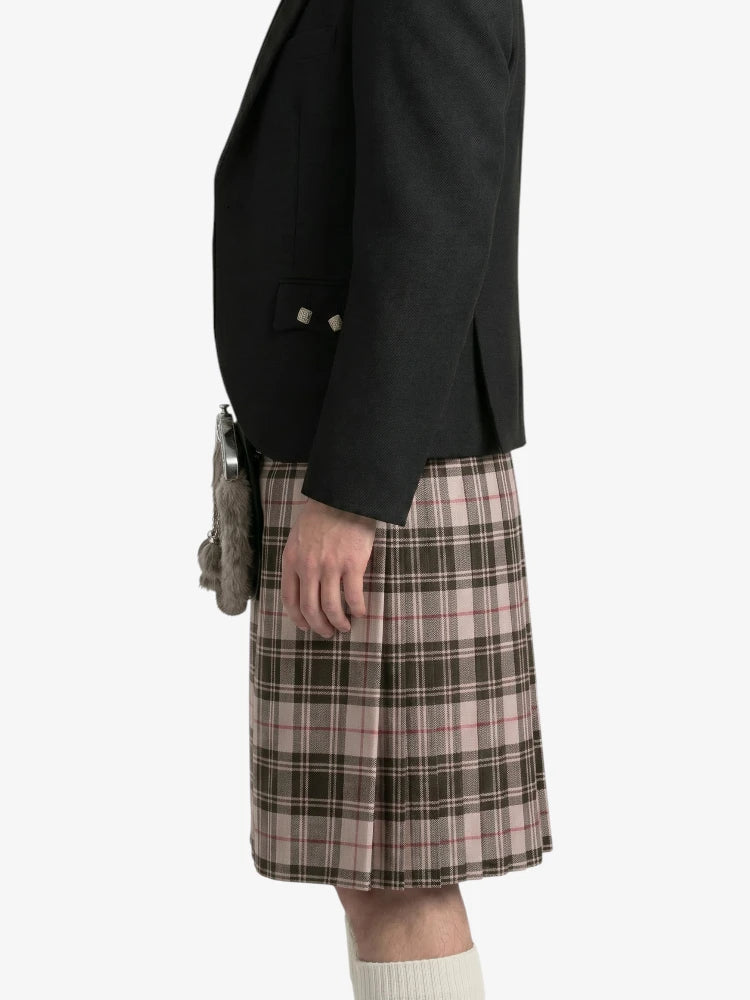 Person wearing a black jacket and plaid kilt  on a white background