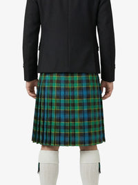 Person wearing a black jacket and green plaid kilt on a white background