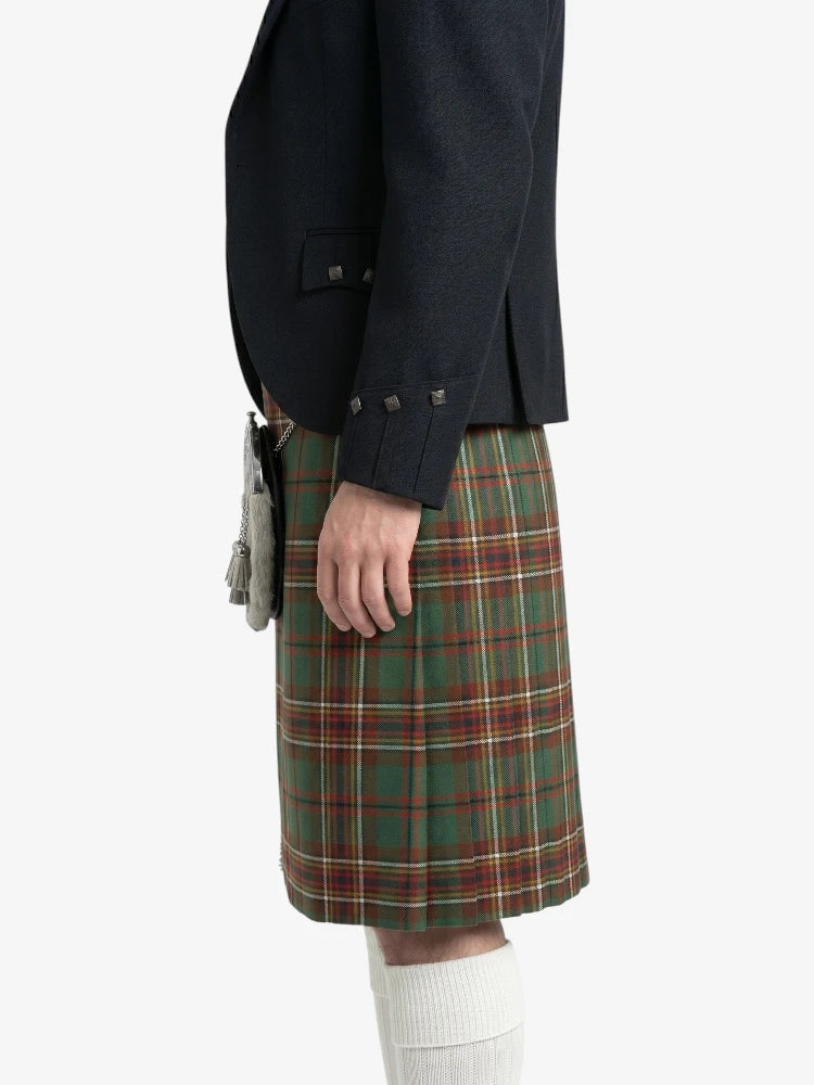 Person wearing a dark jacket and green plaid kilt on a white background