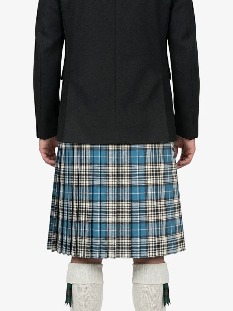 Person wearing a black coat and plaid kilt on a white background