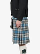 Person wearing a black jacket and blue plaid kilt on a white background