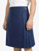 Person wearing a blue pleated skirt with a white top on a white background