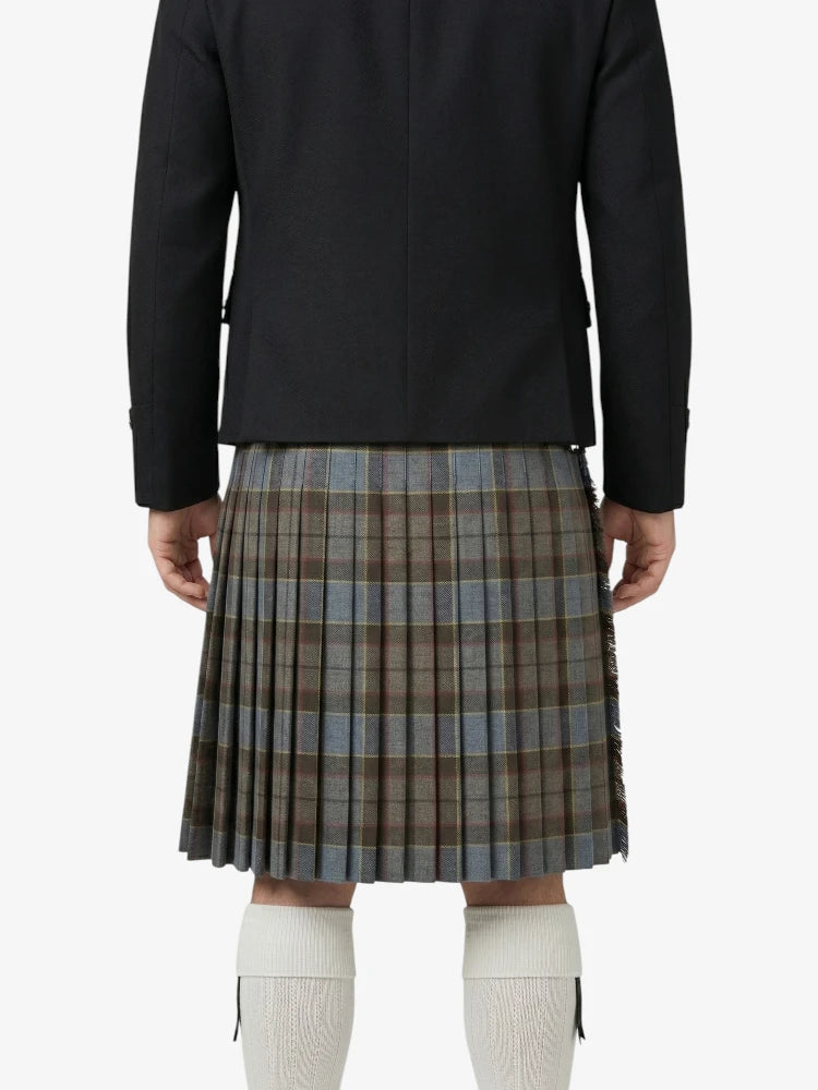 Person wearing a black jacket and plaid kilt on a white background