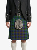 Person wearing a Scottish kilt with a tartan pattern on a white background