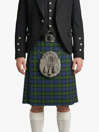Person wearing a Scottish kilt with a tartan pattern on a white background