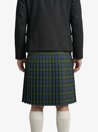 Person wearing a black coat and green plaid kilt on a white background