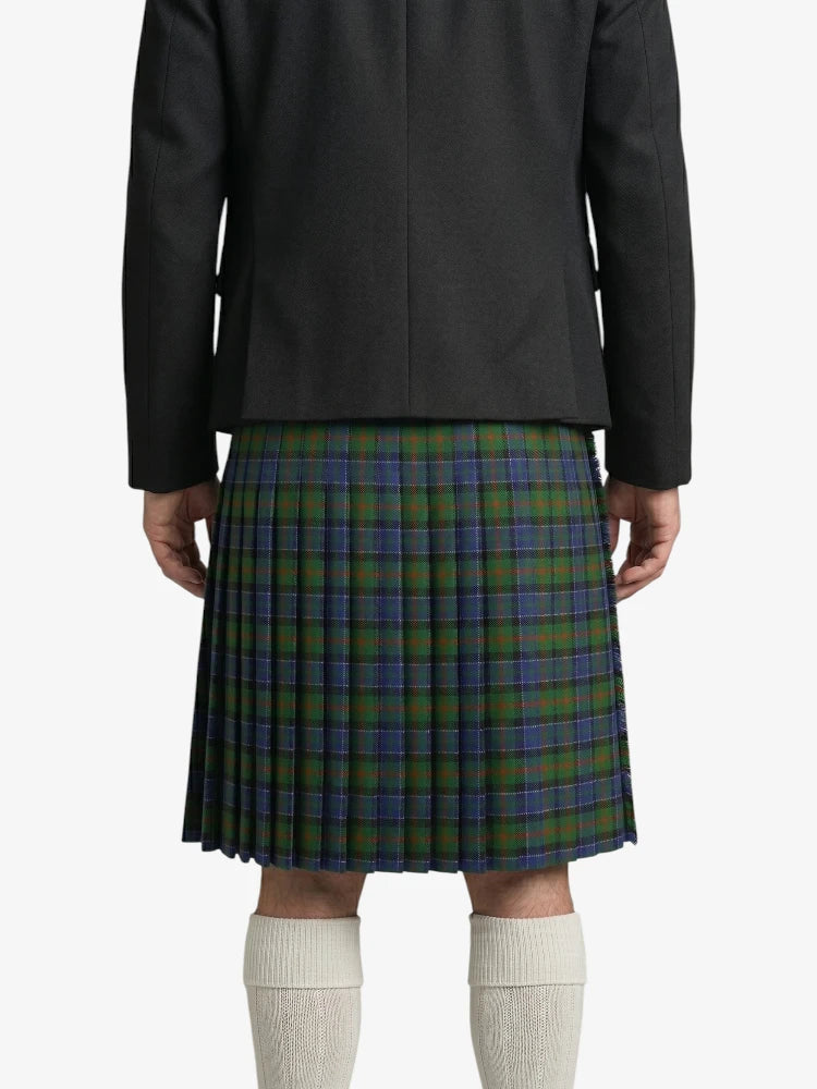 Person wearing a black coat and green plaid kilt on a white background