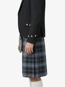 Person wearing a black blazer and plaid kilt on a white background