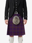 Person wearing a traditional Scottish kilt with a tartan pattern on a white background