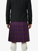 Person wearing a black jacket and purple plaid kilt on a white background