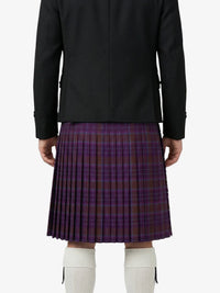 Person wearing a black jacket and purple plaid kilt on a white background