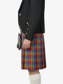 Person wearing a black jacket and colorful plaid kilt on a white background