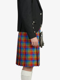 Person wearing a black blazer and colorful plaid kilt on a white background