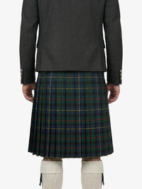 Person wearing a dark gray jacket and green plaid kilt on a white background