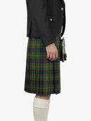 Person wearing a dark jacket and green plaid kilt on a white background