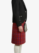 Person wearing a black blazer and red plaid kilt on a white background