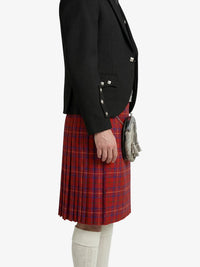 Person wearing a black blazer and red plaid kilt on a white background