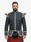 Man wearing a dark grey jacket with white trim and a royal stewart tartan kilt on a white background