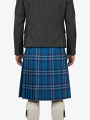 Person wearing a gray jacket and blue plaid kilt on a white background