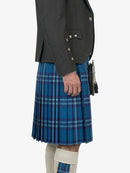 Person wearing a gray jacket and blue plaid kilt on a white background
