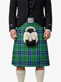 Person wearing a green and blue plaid kilt with a black jacket on a white background