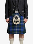 Person wearing a blue plaid kilt with a black jacket on a white background