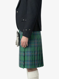 Person wearing a dark jacket and green plaid kilt on a white background