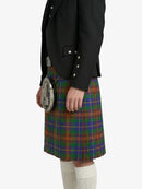 Person wearing a black jacket and tartan kilt on a white background