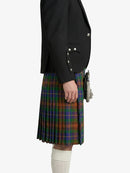 Person wearing a black blazer and plaid kilt on a white background