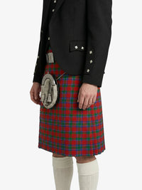 Person wearing a black jacket and red plaid kilt on a white background