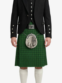 Person wearing a green tartan kilt with a black jacket on a white background