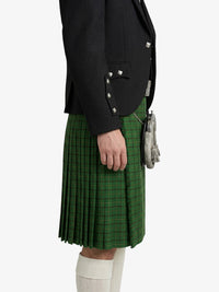 Person wearing a black jacket and green plaid kilt on a white background