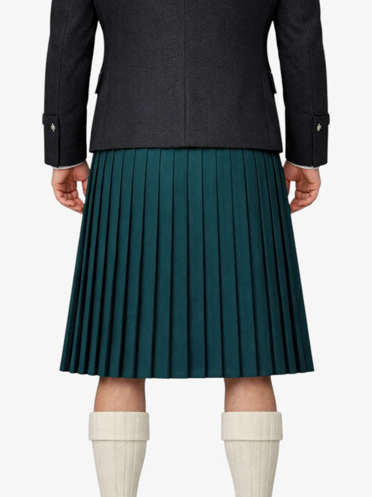 Person wearing a dark coat and green pleated kilt on a white background